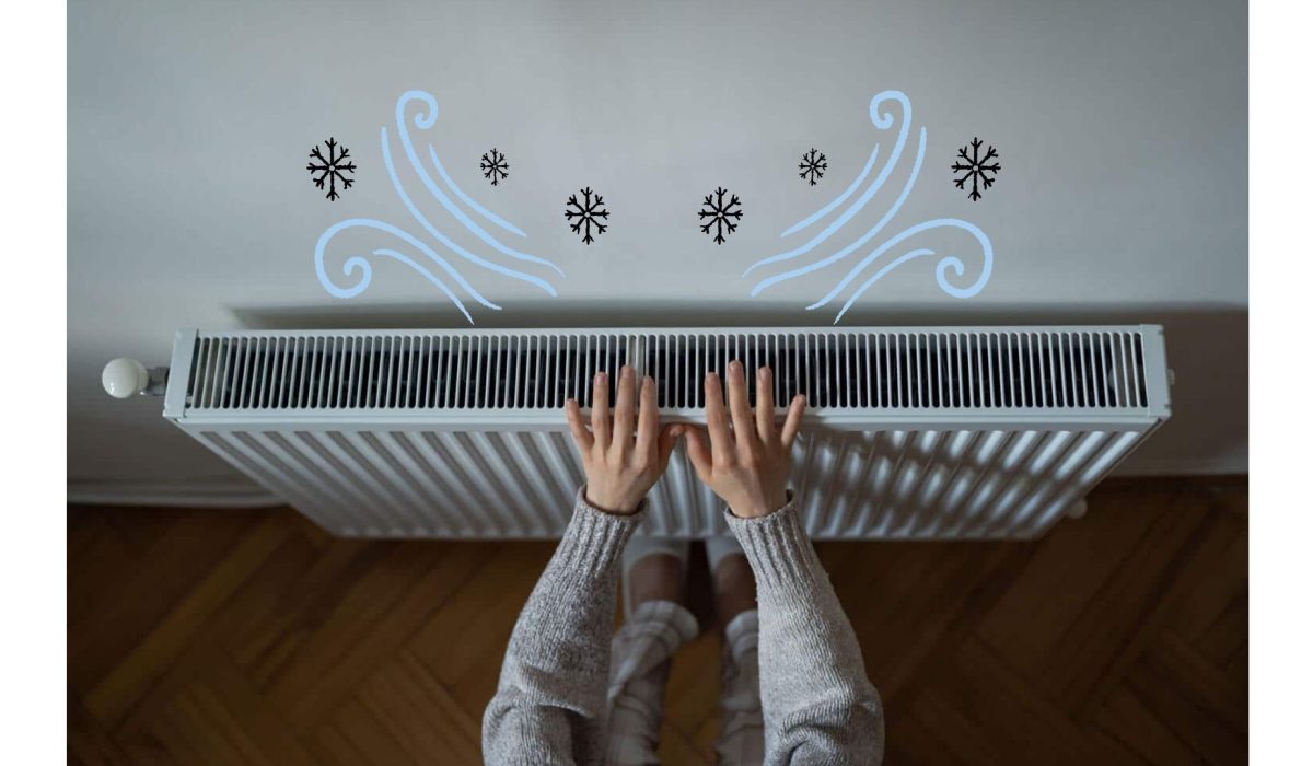 Homeowner warming hands over Boost Air Heating and Cooling radiator in cold weather